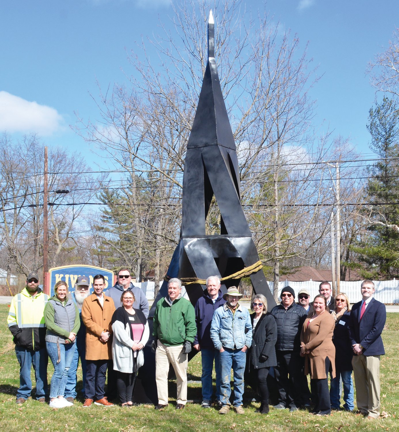 Members of the Paris Chamber of Commerce and other bystanders gather for a photo in front of Paris’ newest sculpture. From left to right, Jesse Ewing, Corby Dayton, City Superintendent Chris Redmon, Tucker Wood, Ryan Kraemer, Tessa Hutson, Doug Hasler, Tom Tuttle, designer
John Chittick, COC Executive Director Linda Lane, City Commissioner Harry Hughes, Cliff Macke, COC President Paige Moreschi, Andrew Garvin, Callie Baber and Phil Dobelstein, Present but not pictured were Craig Smith, COC Vice President Sondi Dobelstein and Bob Colvin.