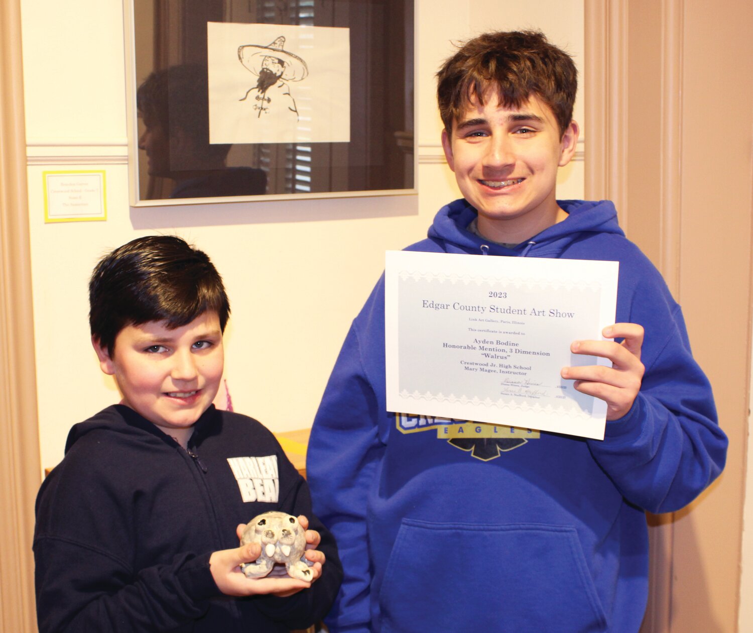 Ayden Bodine, right, received an honorable mention for his ceramic sculpture at Link Art Gallery’s Edgar County Student Art Show. He encouraged his little  brother, Liam, to help by naming the finished piece, and the younger boy is holding “Wally, the Walrus.”