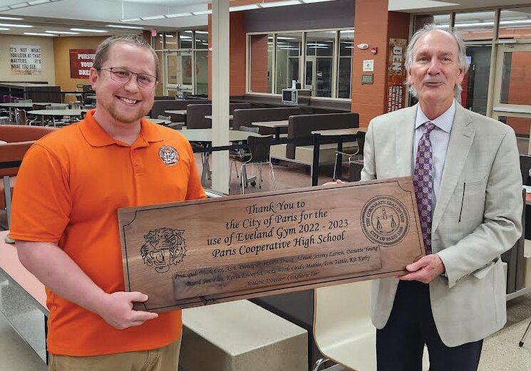 Mayor Craig Smith, right, accepts a plaque manufactured by PHS students from PHS teacher Graham Bennett, left, on behalf of the city for the help the city gave the high school after the December flooding of the gym.