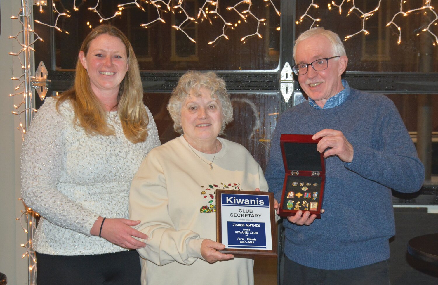 Betsey Higginbotham (left) and Dennis Theil (right) members of the Paris Kiwanis Club presented a plaque to Cindy Mathis (center), the widow of Jim Mathis, a long-time member of the Club.